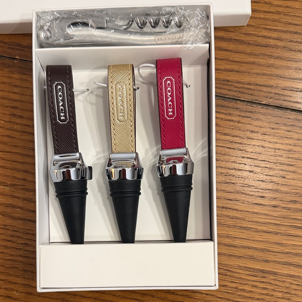 Coach Brown, Gold, and Pink Wine Stoppers with Coach inscribed corkscrew